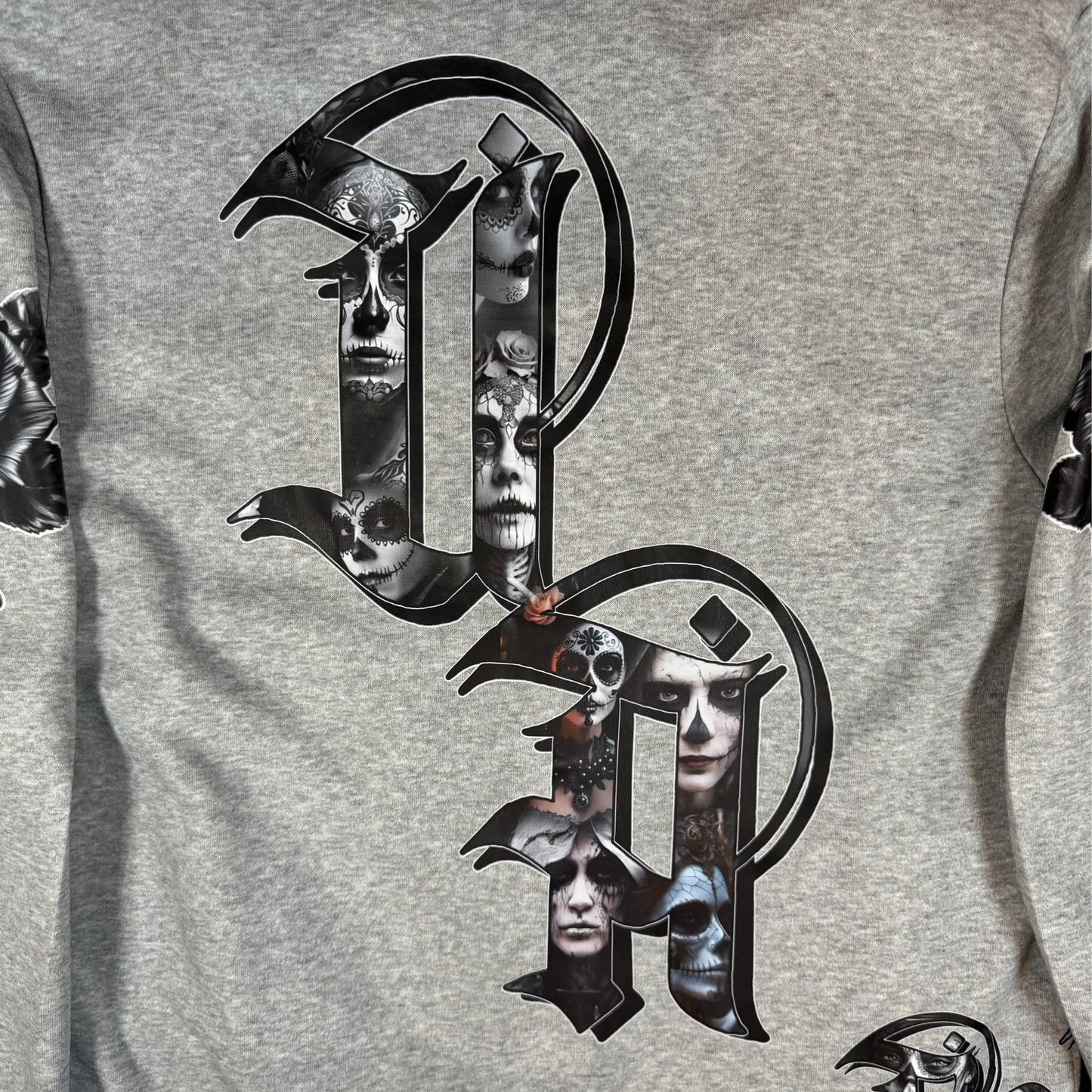 Close-up of gothic Old English UA lettering filled with detailed Day of the Dead skull faces and portrait artwork.